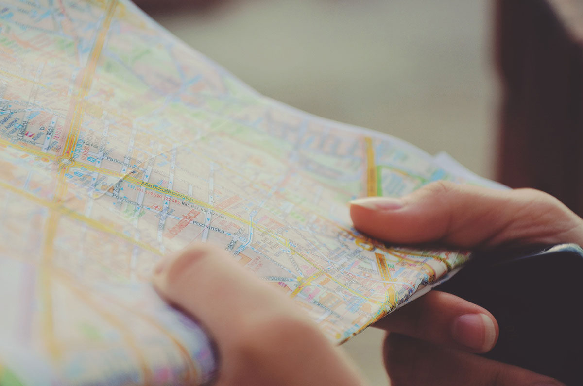 Hands holding folded paper city map